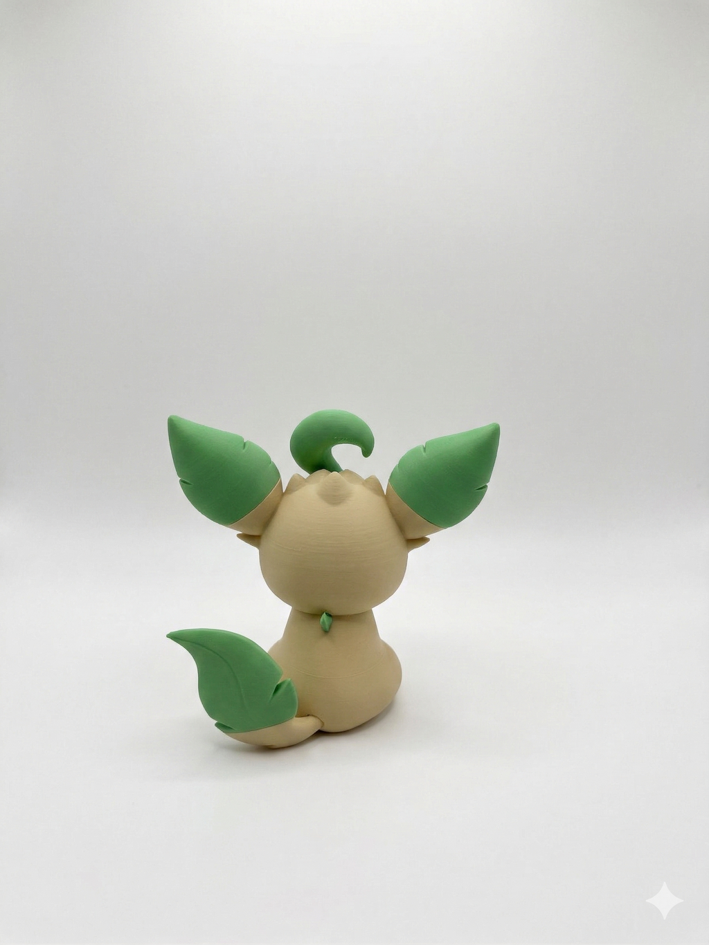 Toy figure of a creature with green leaf-like appendages on a white background